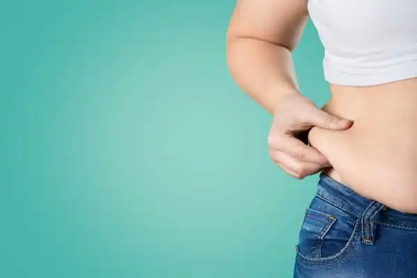 Image of woman pinching her love handles to show weight gain Chinnor